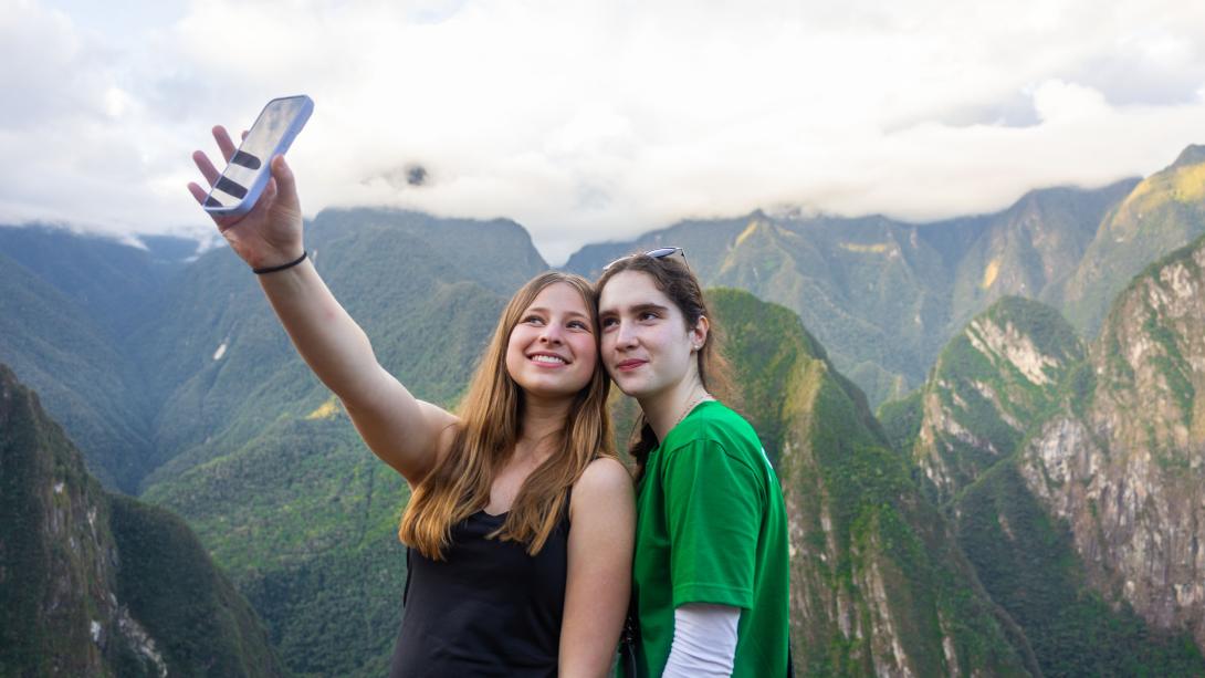 Two young participants take a selfie near Machu Picchu, Peru